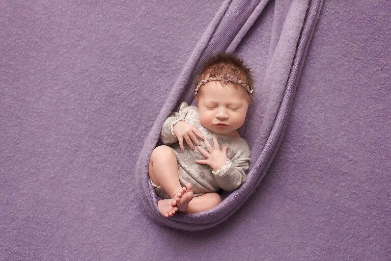 newborn photographer fort worth, baby girl in purple lying on back
