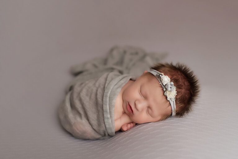 baby girl photos texas, newborn in gray wrap asleep on tummy